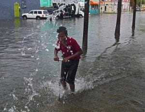 A young boy has fun with his razor scooter during the flood rains