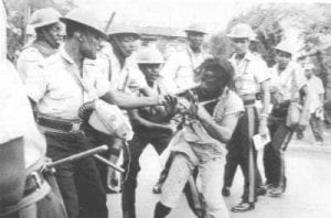 A file photo of a Rastafarian being harassed by Jamaican police during the Coral Gardens incident
